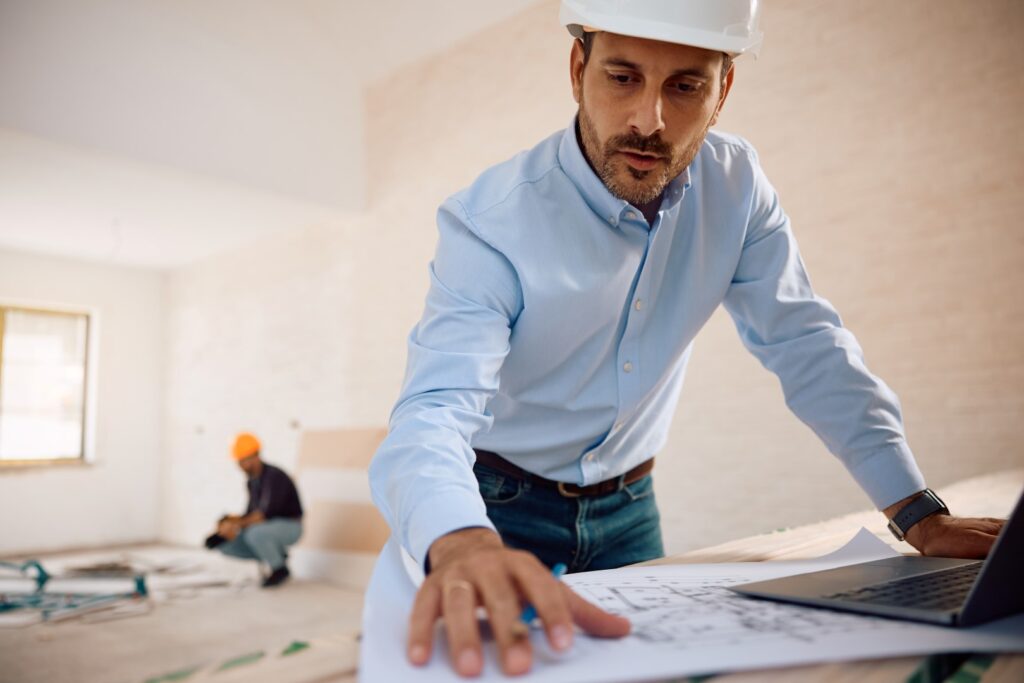 General contractor reviewing blueprints on-site.